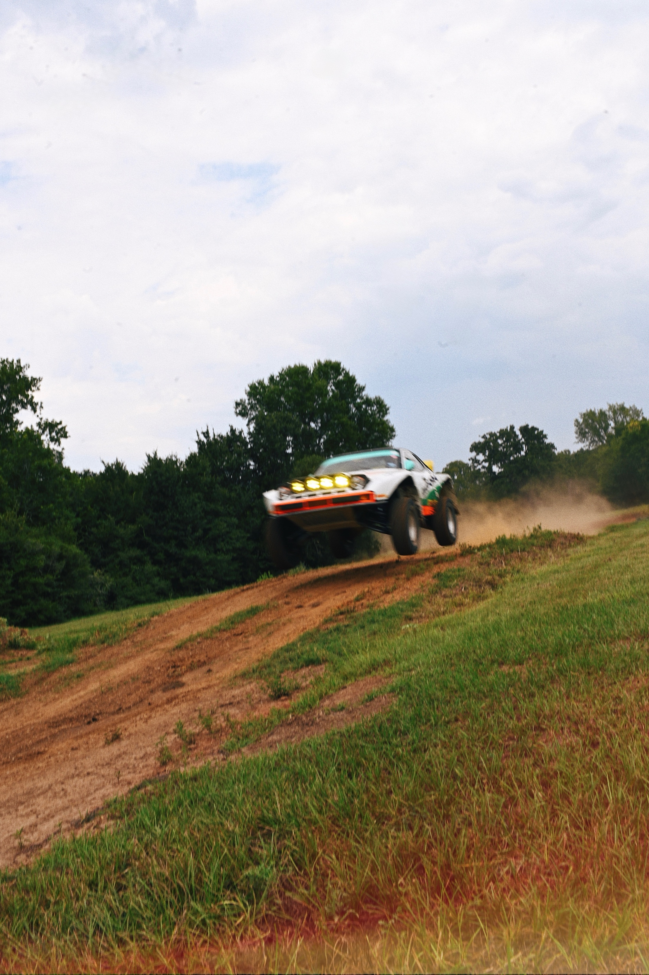 Rally Porsche airborne on a dirt course