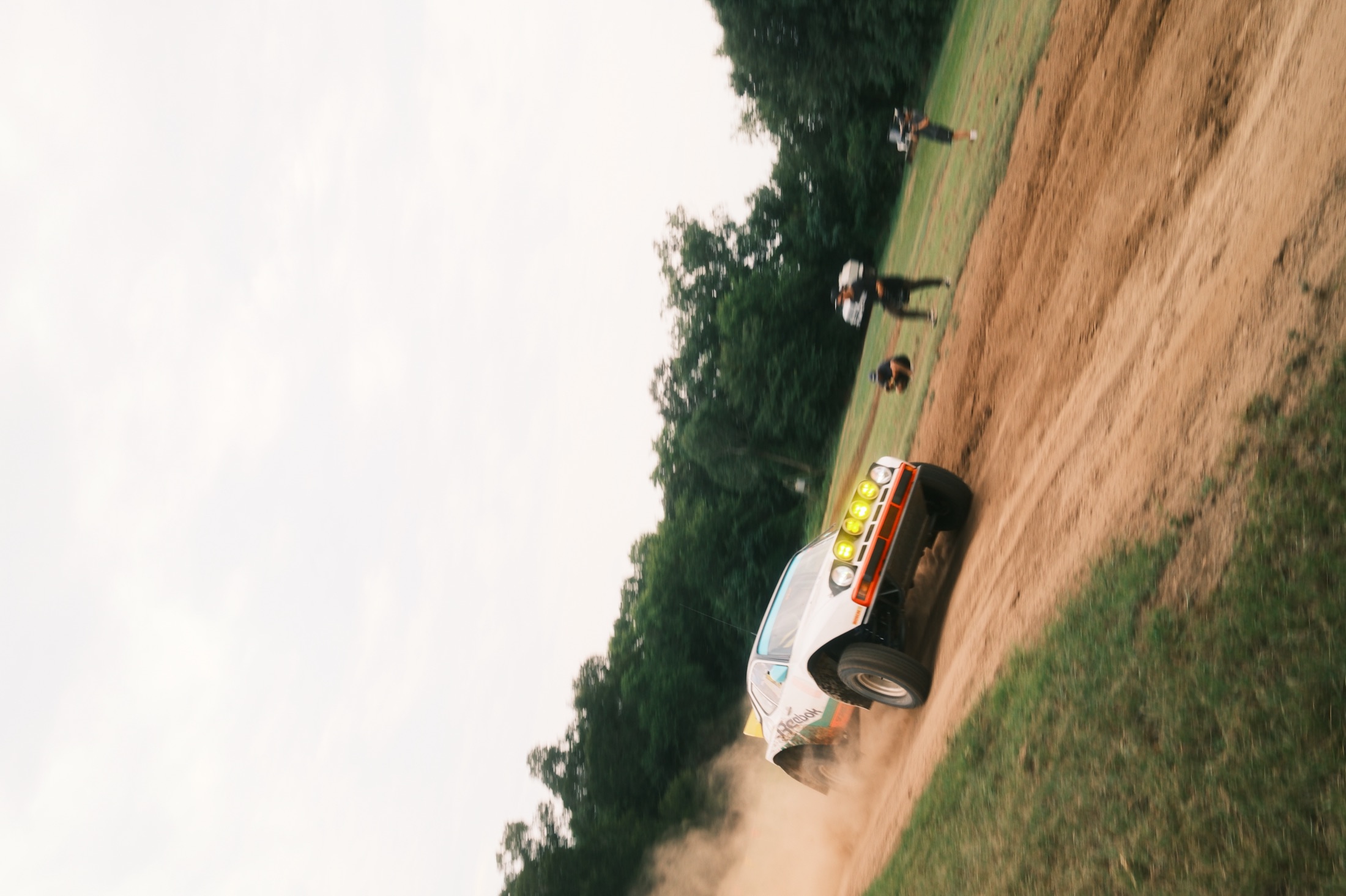 Rally Porsche driving toward camera through dust